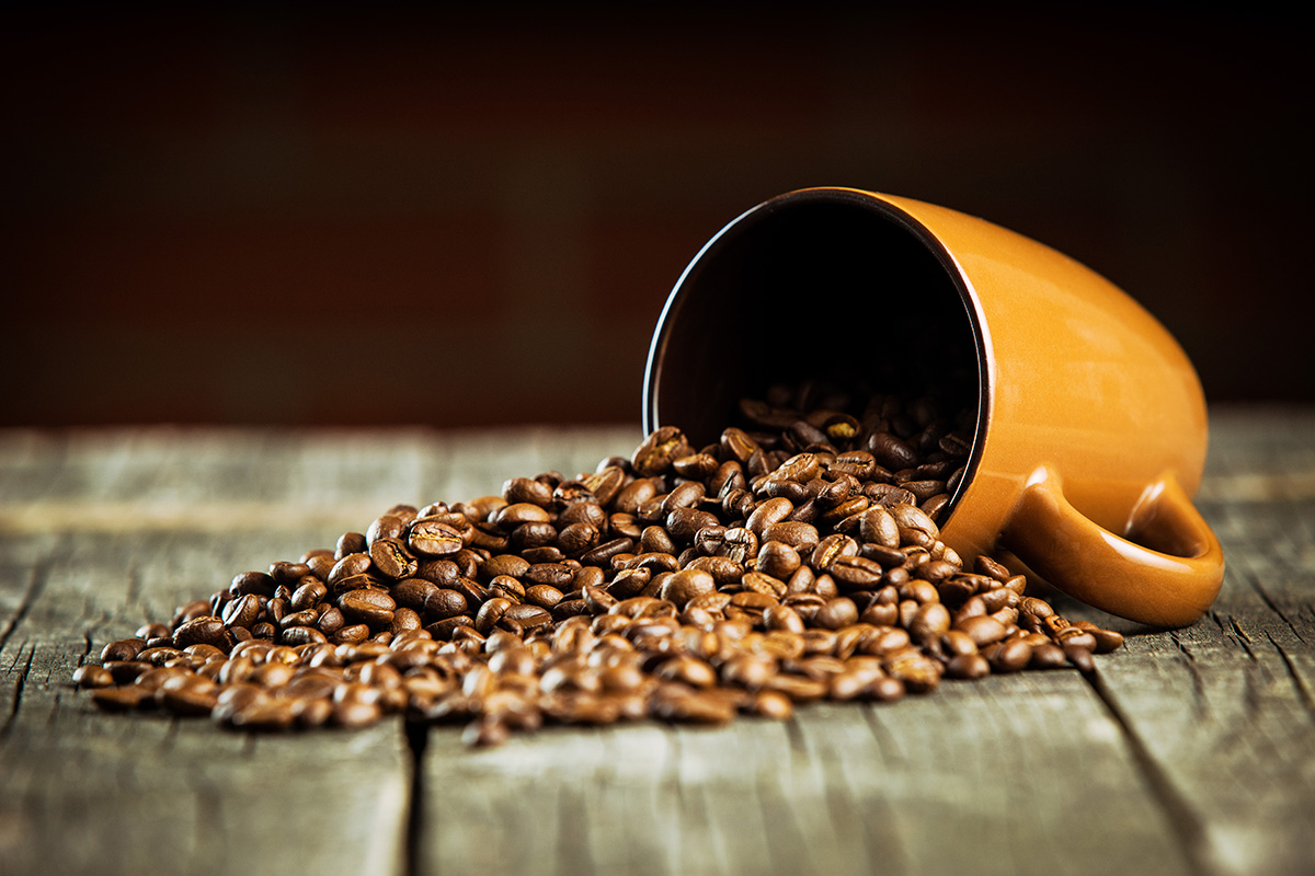Coffee beans and coffee mug on wooden table