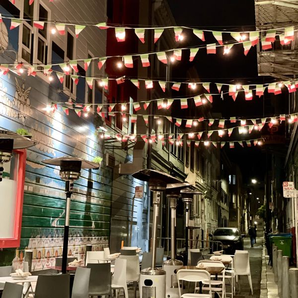 North Beach food tour: nighttime alley festooned with string lights and Italian bunting in San Francisco’s North Beach.