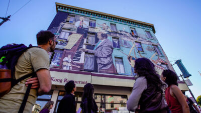 North Beach food tour: participants admiring a jazz-and-piano mural on a North Beach building in San Francisco.