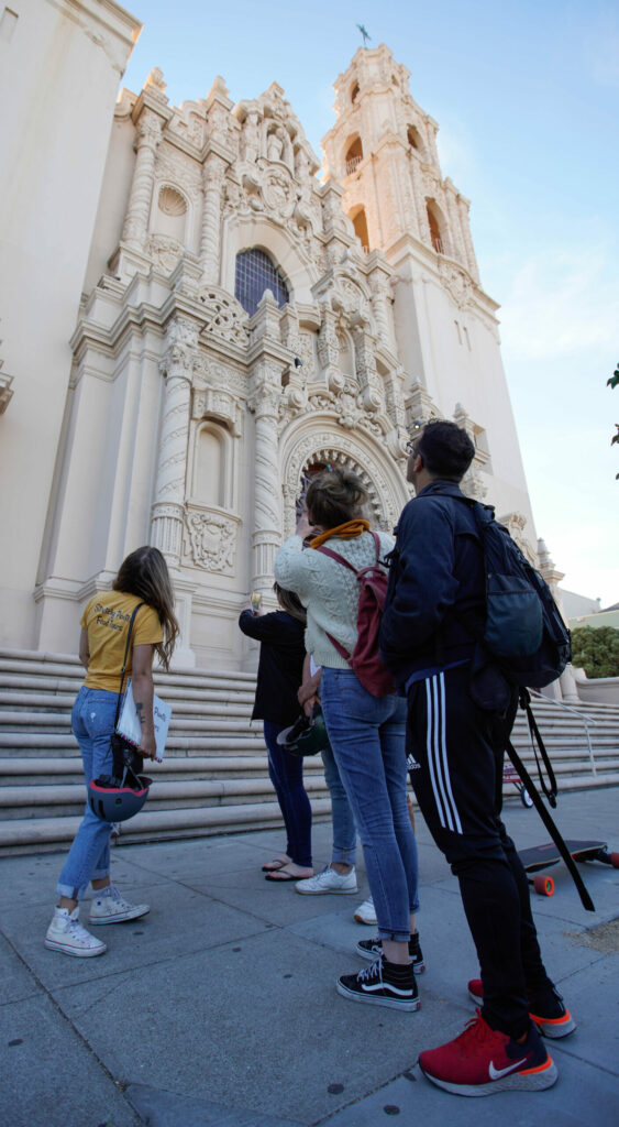 Team building San Francisco: Small group looking up at the ornate façade of a historic San Francisco building—team building food tour architectural stop.